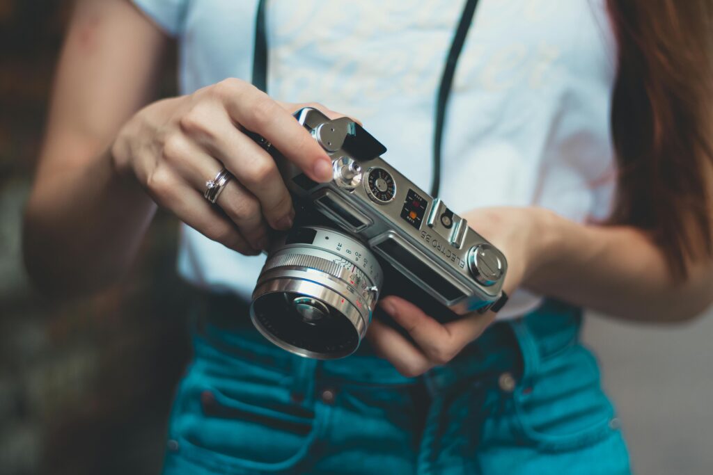 woman in white shirt holding analog camera