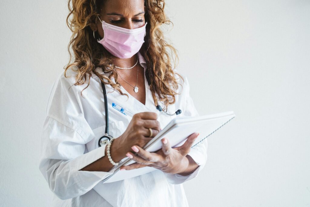 doctor in face mask taking notes