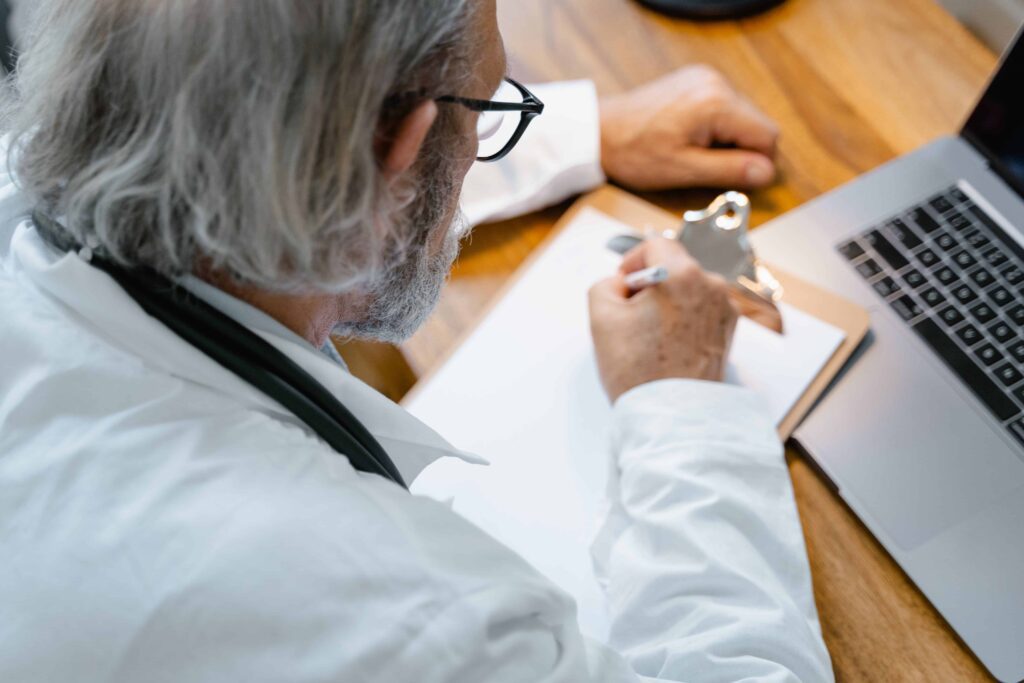 doctor writing on a clipboard