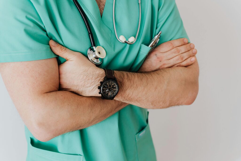 doctor in green scrubs crossing arms