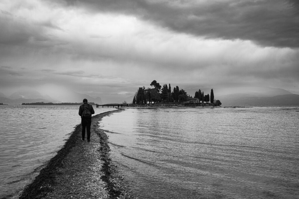 man on footpath walking towards island