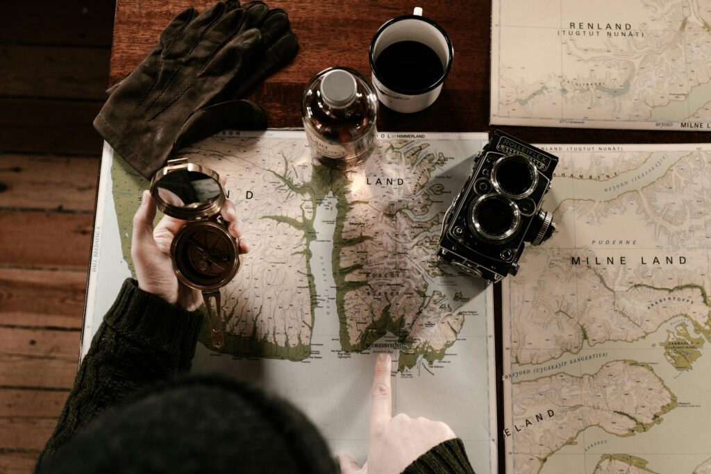 man looking at map and holding a vintage compass