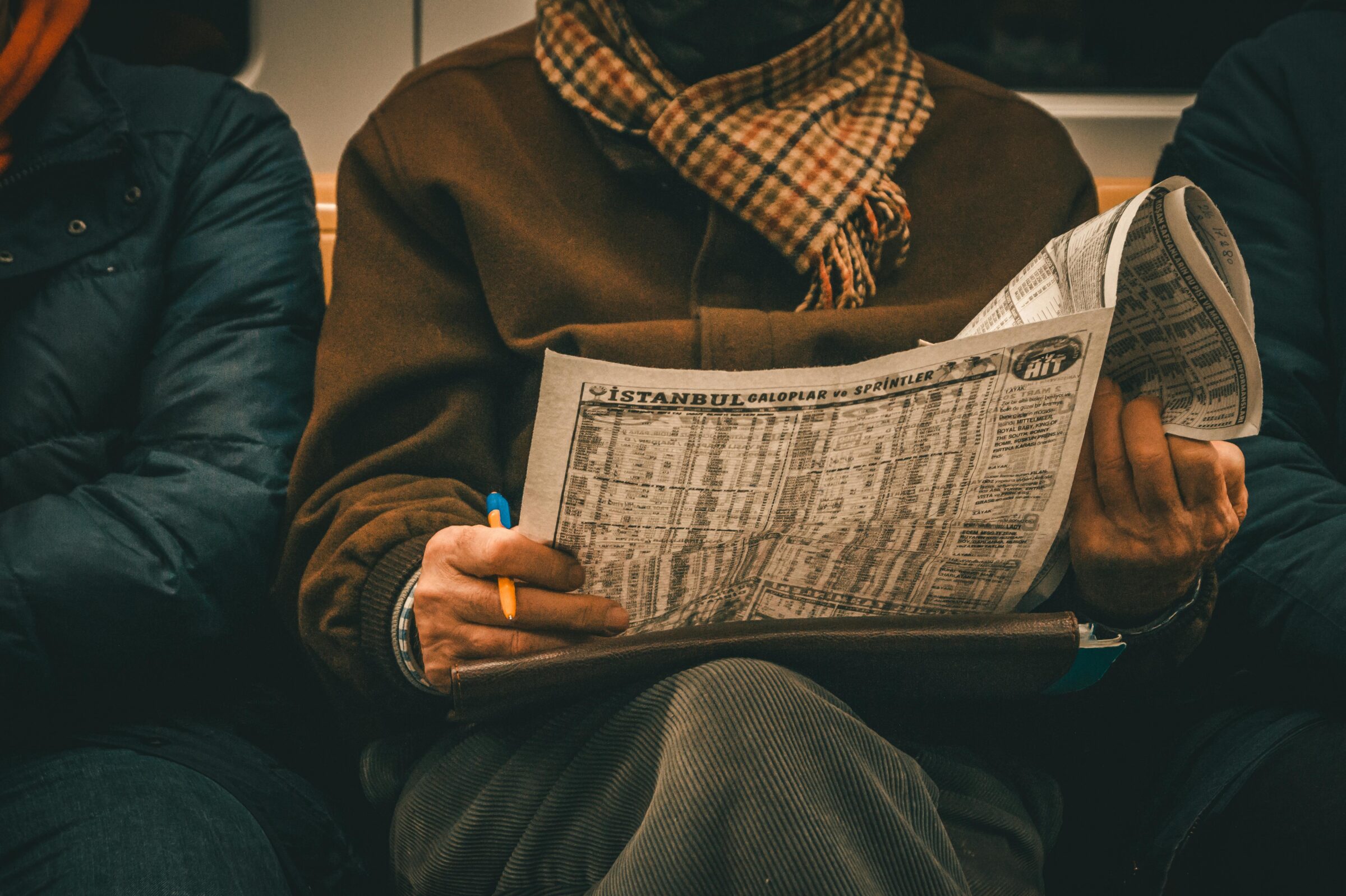 close up of person sitting and holding newspaper