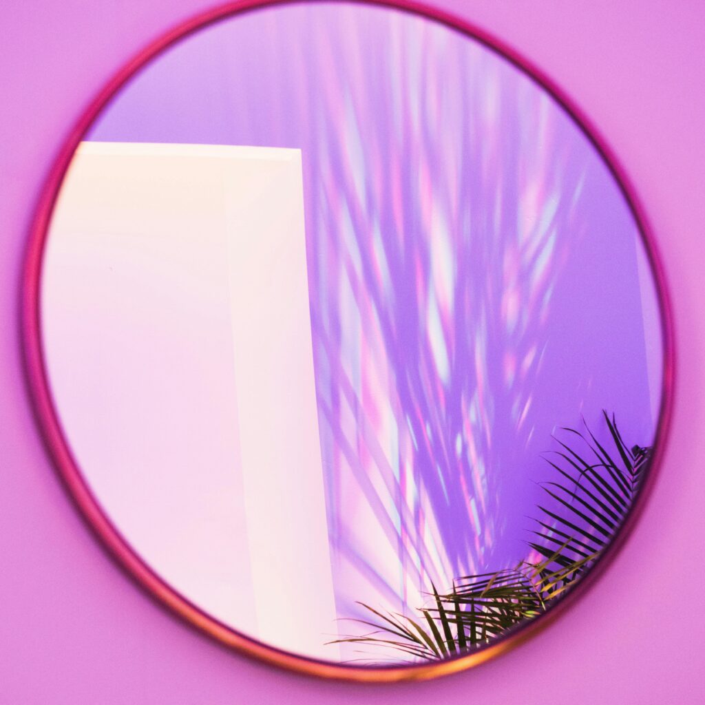 round mirror on pink wall