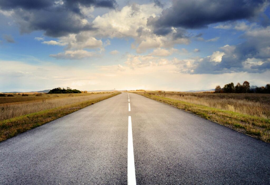 asphalt road under cloudy sky