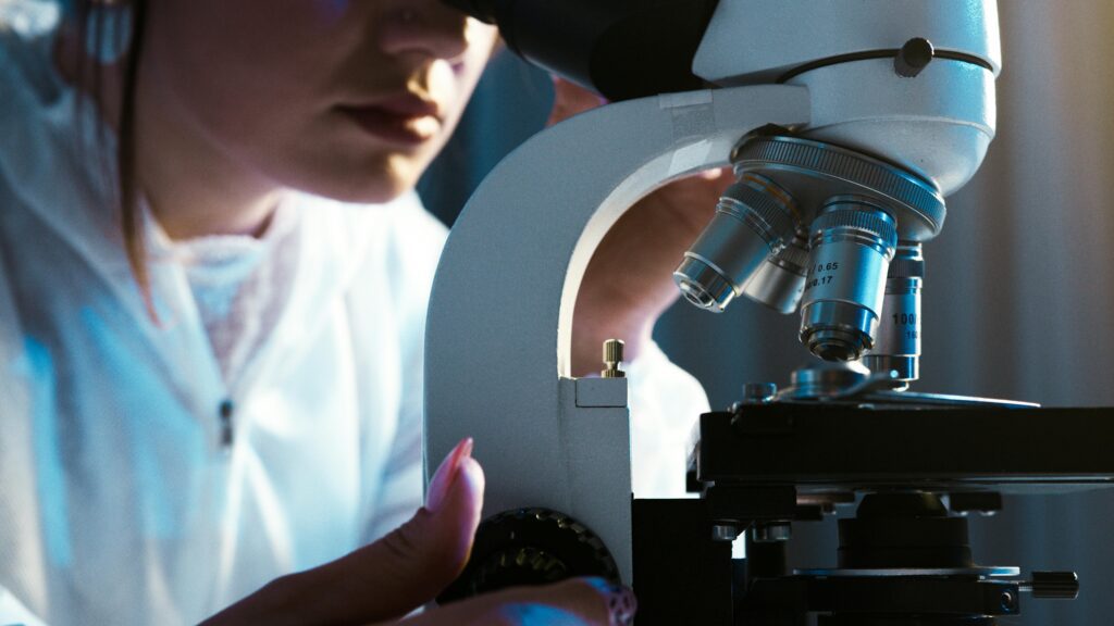 person looking through microscope